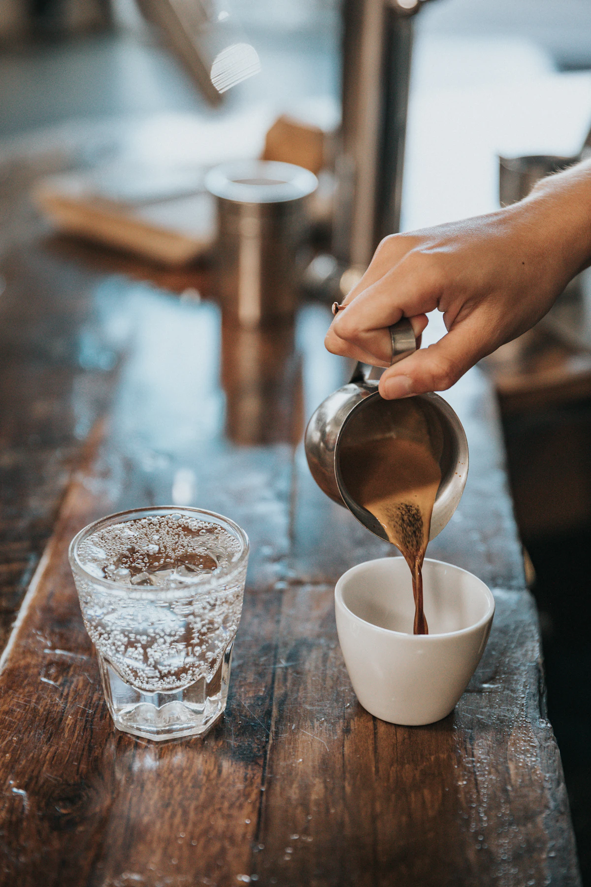 白いマグカップへ丁寧にコーヒーを注ぐ手元